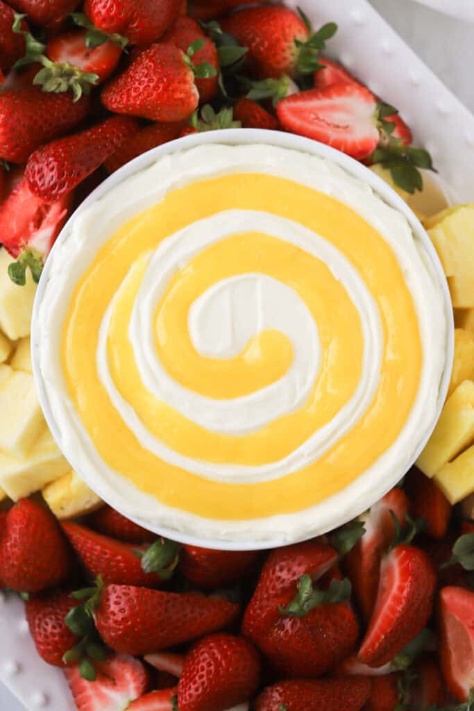 lemon Cheesecake Fruit dip on a platter wiith fresh strawberries and pineapple