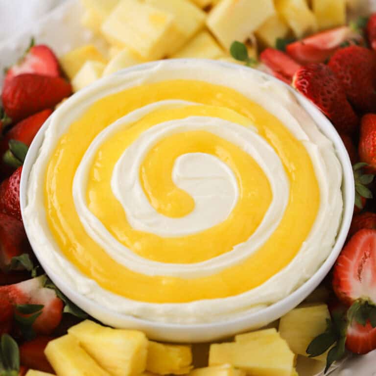 lemon Cheesecake Fruit dip on a platter wiith fresh strawberries and pineapple, best dip for fruit. lemon curd swirl on a lemon cheesecake fruit dip