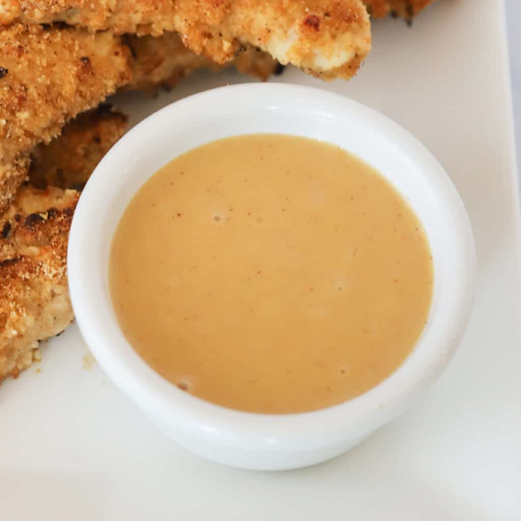 How to Make Homemade Honey Mustard sauce in a white ramekin. Honey mustard recipe, honey mustard sauce recipes, best honey mustard dipping sauce. Mustard sauces.