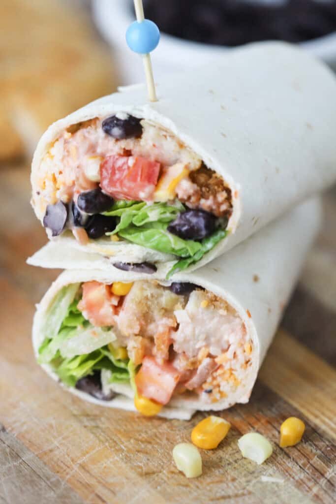 A Southwestern crispy chicken wrap cut in half with a toothpick stuck through the middle.
