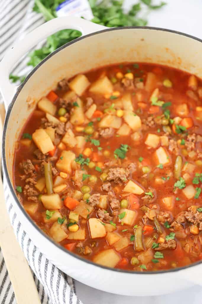 A dutch oven full of veggie soup with ground beef. homemade vegetable beef soup recipes. vegetable soup recipe with ground beef. 