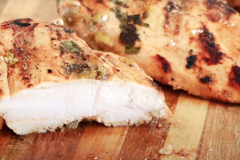 best chicken marinade, grilled chicken with cilantro crema on cutting board. 