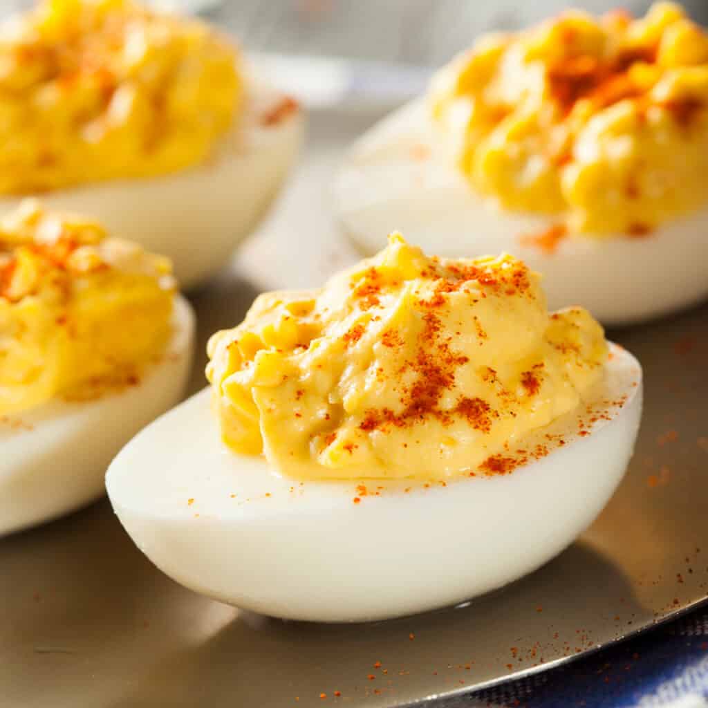 deviled eggs for a baby shower topped with paprika.