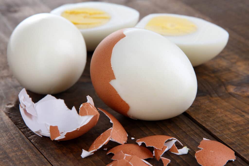 A hard boiled egg being peeled.