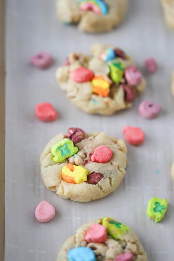 Baked cookies topped with Lucky Charms marshmallows, and other lucky charm cookie dough ingredients. How to make a lucky charm cookie.