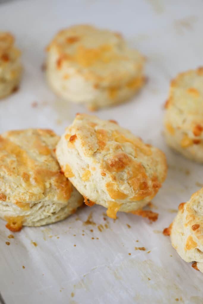 Homemade cheddar biscuits on parchment paper; the best recipe for easy cheddar cheese biscuits.