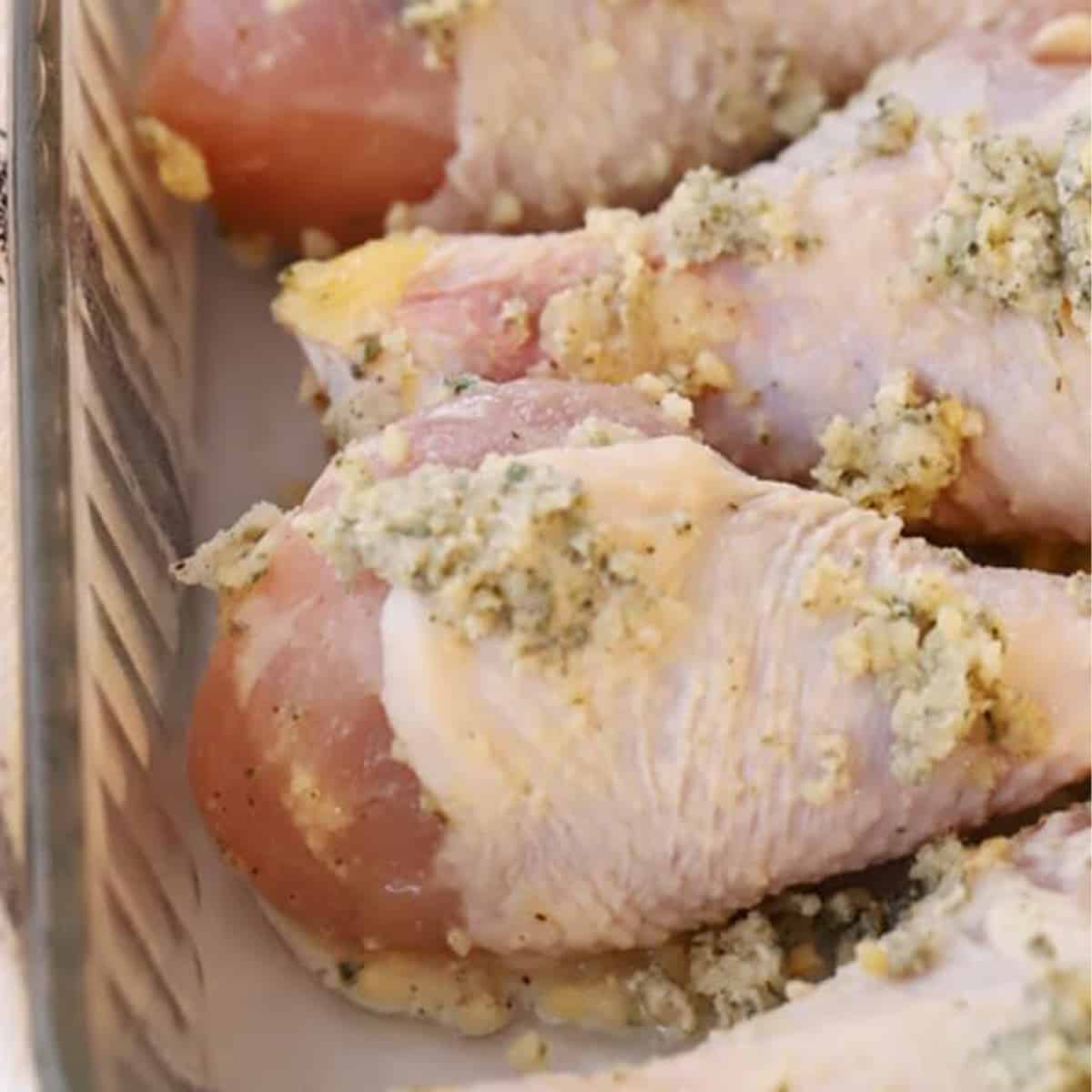 garlic parmesan drumsticks with a sprig of parsley on a white platter, best chicken drumstick recipe, baked chicken leg recipe ideas.