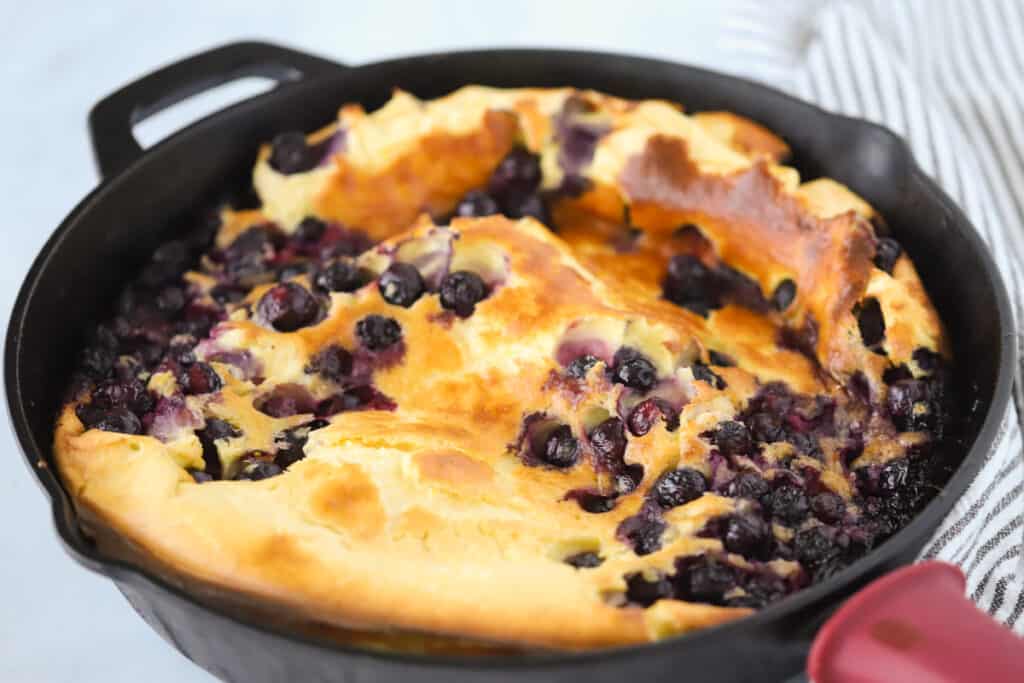 German pancake recipe with lemon and blueberry in a cast iron skillet. Best dutch baby recipe. Lemon blueberry dutch baby recipe.