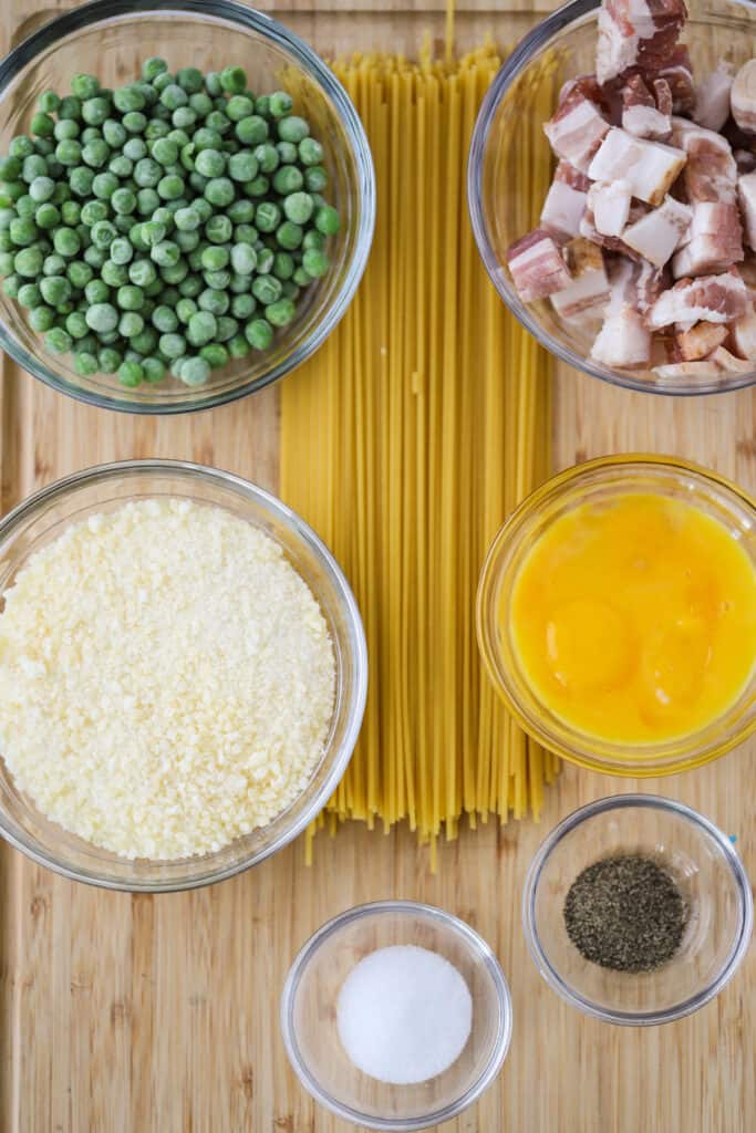 Ingredients to make this Spaghetti Carbonara recipe in separate bowls.