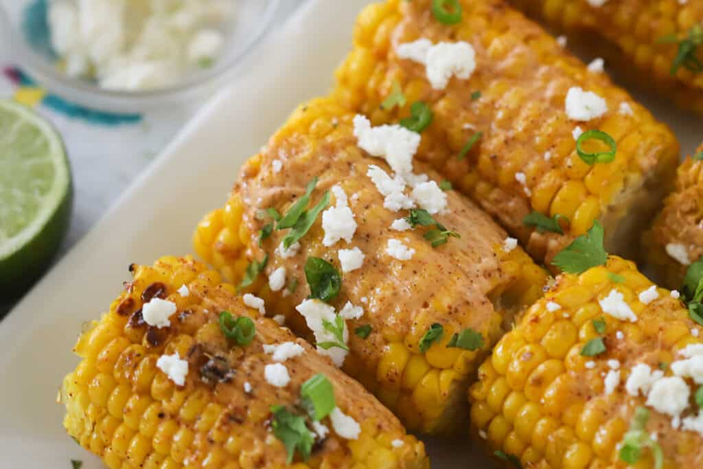 Best mexican street corn recipe topped with cotija cheese and fresh chopped cilantro.