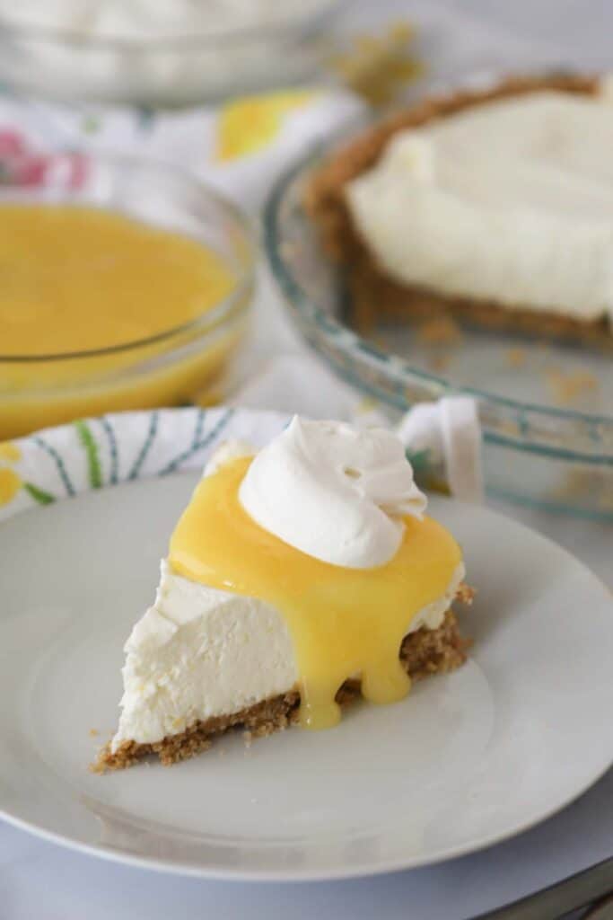Slice of no bake lemon cheesecake topped with lemon curd and whipped cream, easy no bake cheesecake, cheesecake recipe no bake.