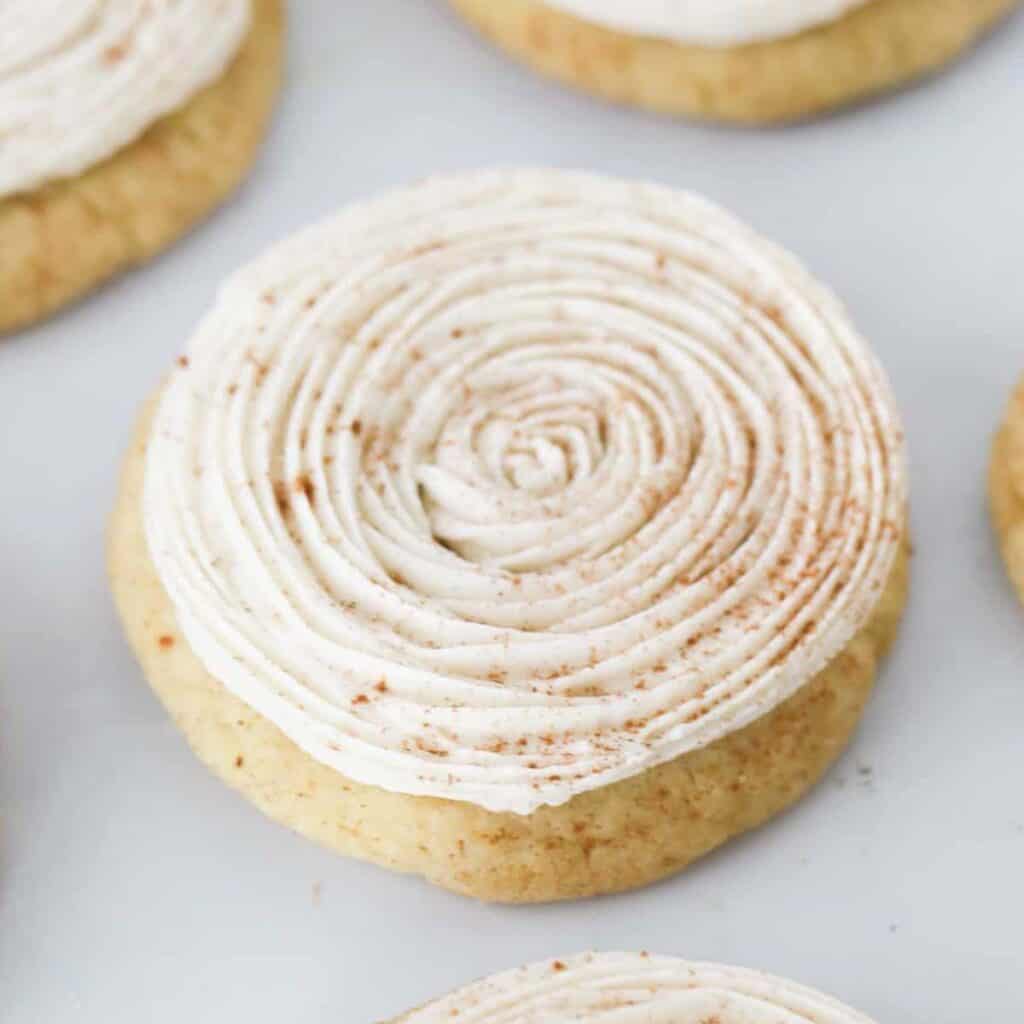 Pumpkin Spice Snickerdoodles topped with frosting and cinnamon.