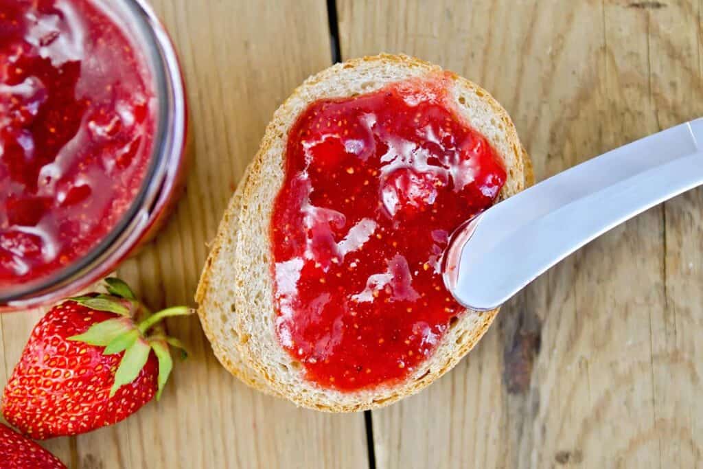 Easy strawberry freezer jam spread on toast. Best freezer jam recipes. Freezer jam strawberry. Recipe strawberry freezer jam. 