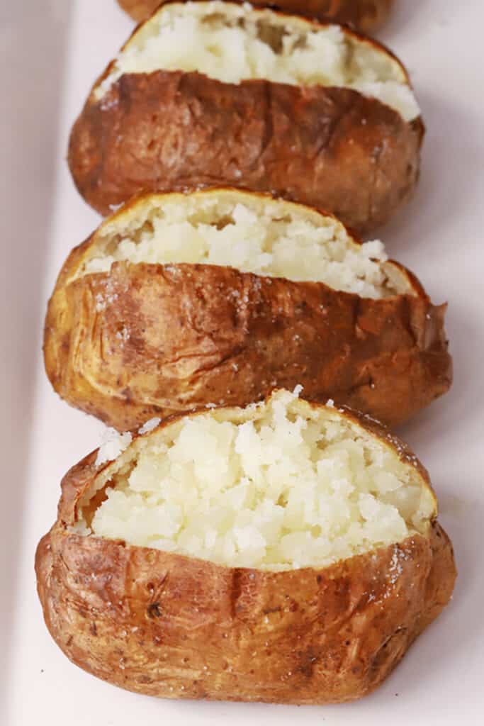 air fryer baked potatoes cooked and fluffed with a fork, air fryer baked potato recipe. baked potato in the air fryer, 