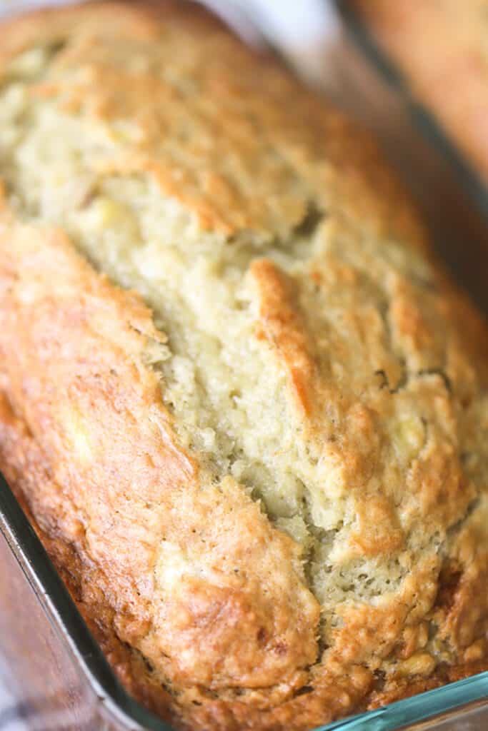 Homemade banana bread in a glass loaf pan. banana bread in a pan, how to make banana bread. soft banana bread recipe easy