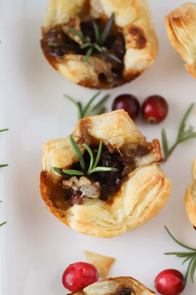 Baked brie bites made with phyllo dough, cranberry sauce, and fresh rosemary.