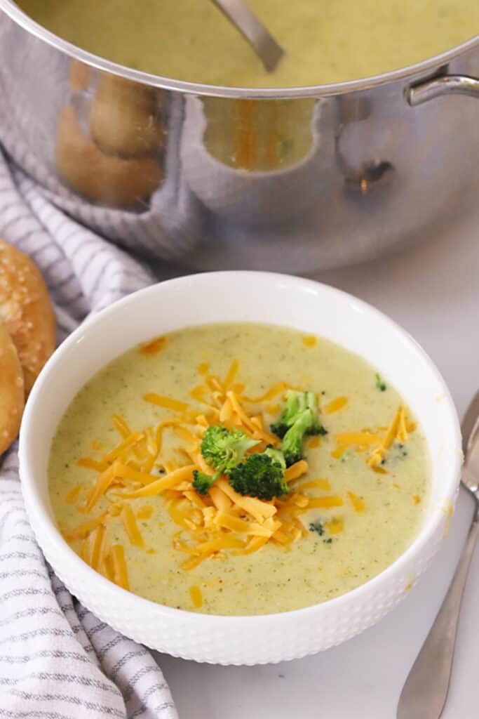 Broccoli potato and cheese soup in a white bowl. crockpot broccoli potato soup, broccoli and potato cheese soup, cheddar broccoli potato soup, cream of broccoli potato soup.