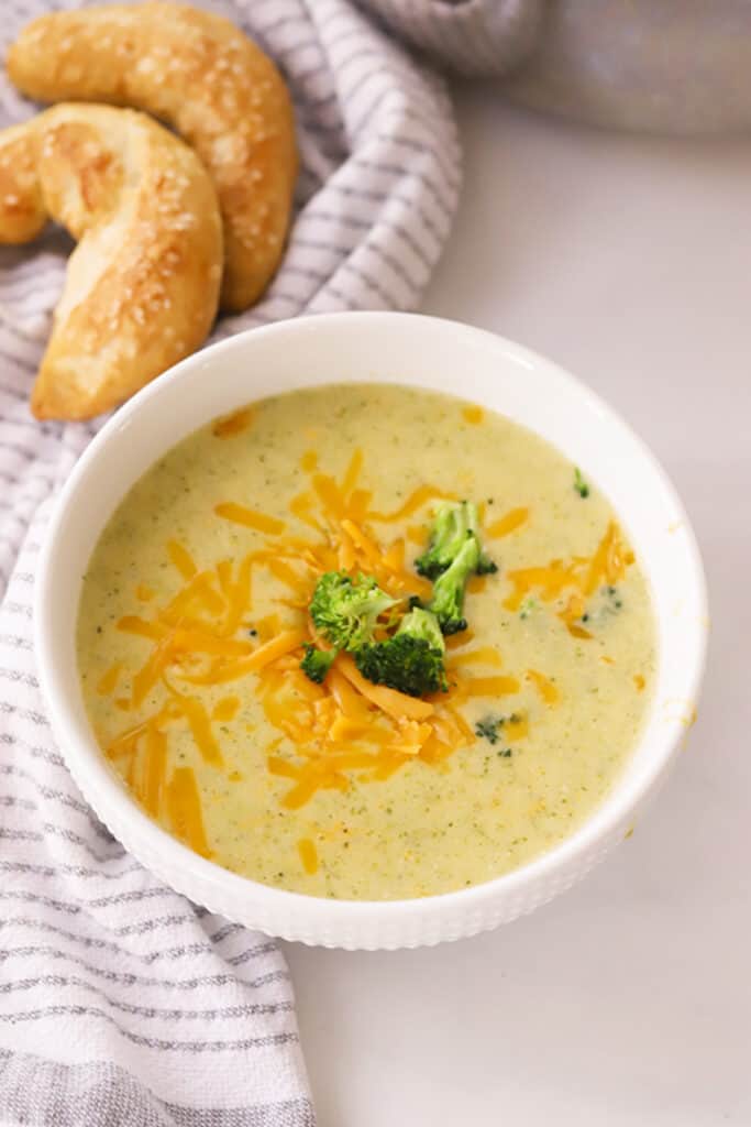 creamy Broccoli Potato cheese soup Recipe in a white bowl with broccoli on top. An easy potato broccoli soup.
