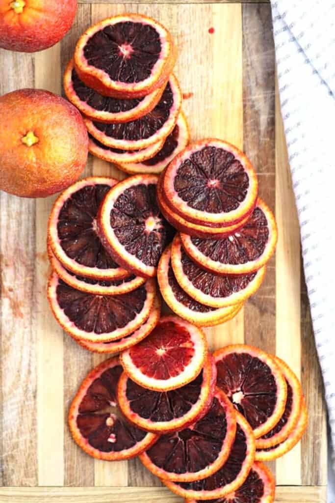 Blood oranges on a a cutting board, ready to make candied citrus; how to make candied lemons.