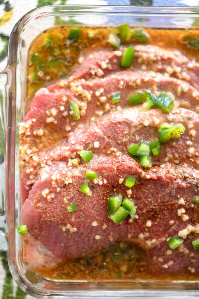 carne asada marinade recipe in a glass baking dish with beef.