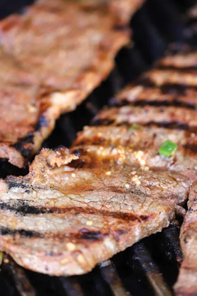 Carne asada cooking on the grill.