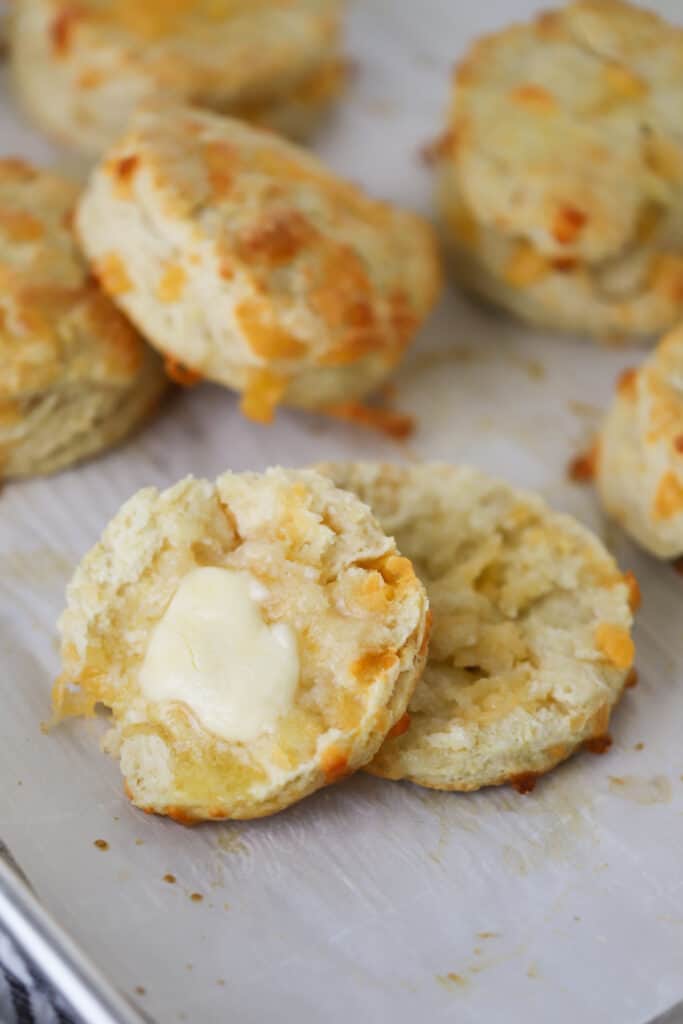 Cheddar cheese biscuits spread with butter, an easy cheesy biscuits recipe.