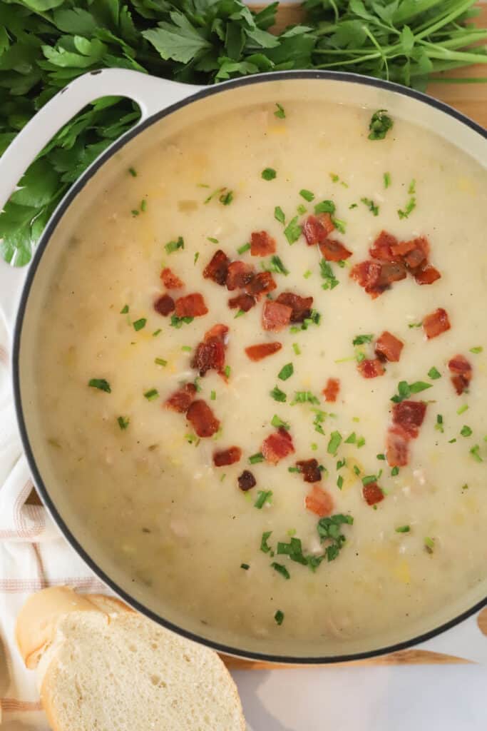 The best easy clam chowder in a dutch oven topped with bacon and chives. This is the absolute best creamy clam chowder recipe.