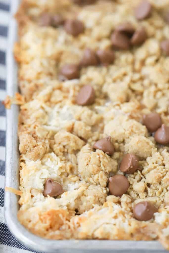 Coconut Caramel Magic Bars in a baking pan with chocolate chips over the top. These are the best coconut caramel cookies.