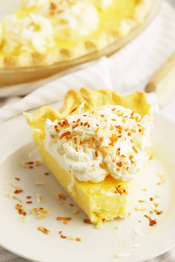 A slice of this old fashioned coconut pie recipe on a plate, made using a creamy coconut cream filling.