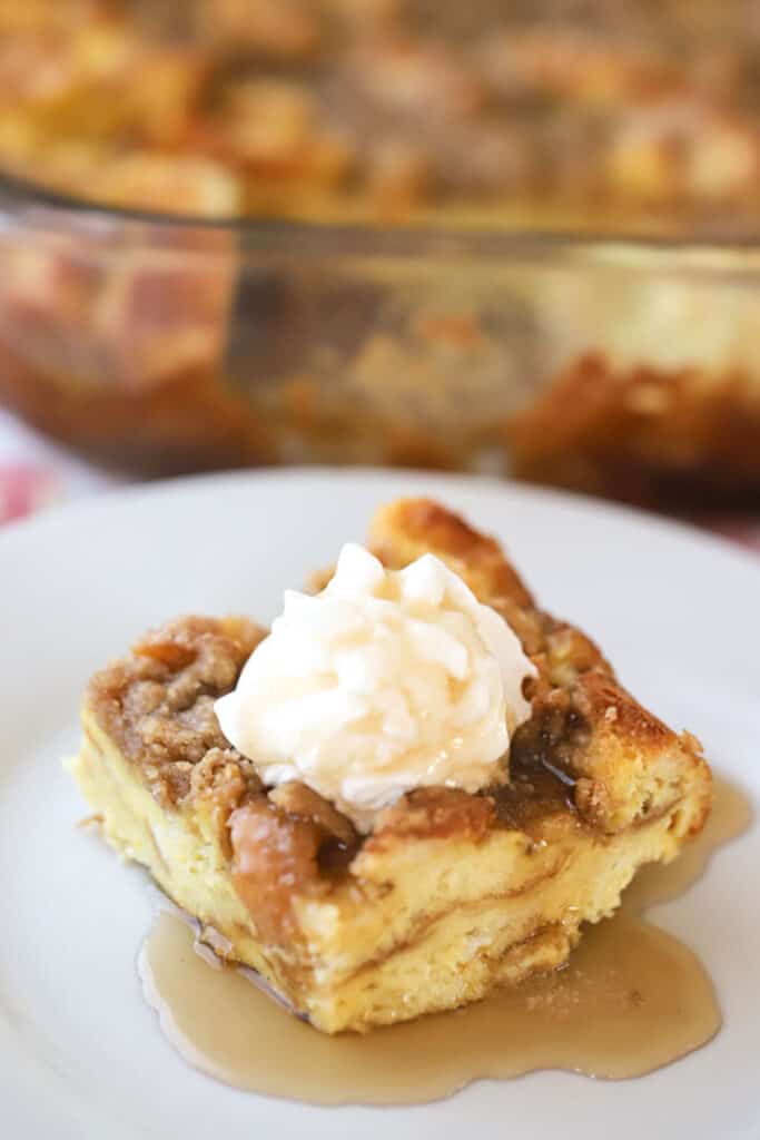 Easy french toast bake with French bread, topped with streusel and whipped cream.