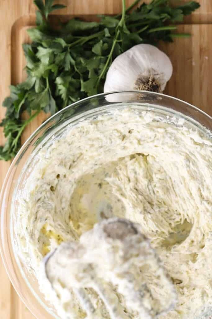 Homemade garlic butter recipe being made in a bowl with a hand mixer. Easy whipped garlic butter.