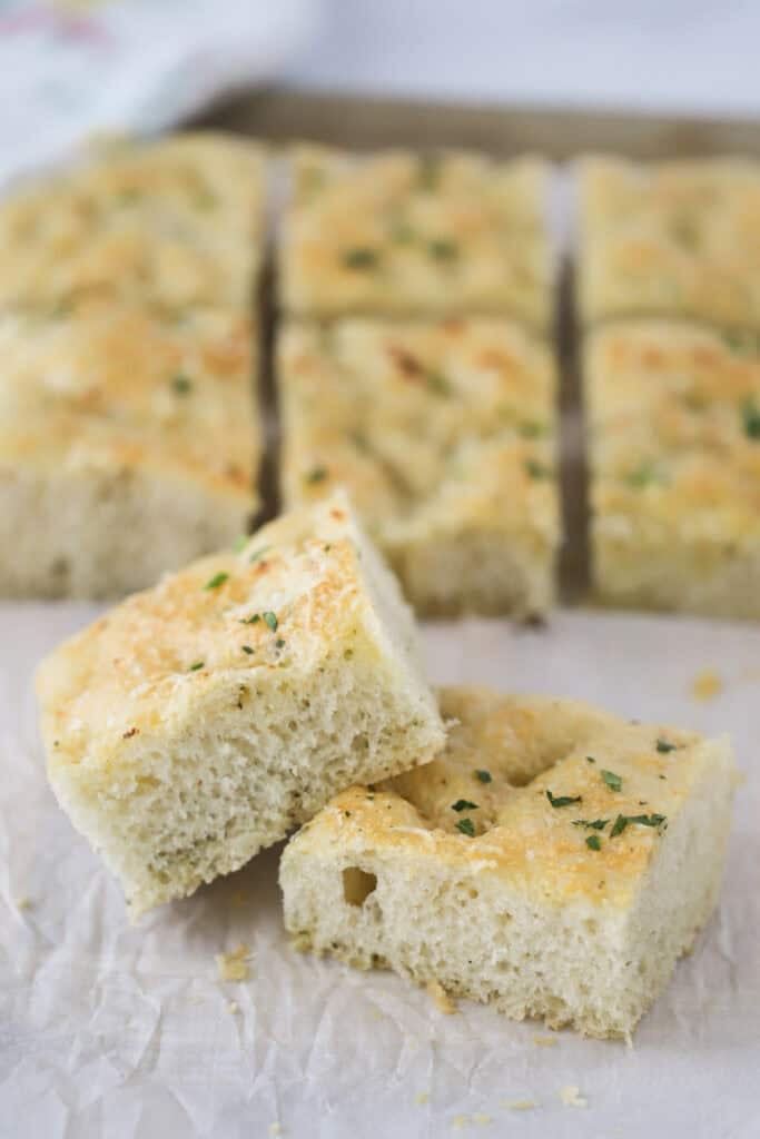 squares of herb focaccia bread on parchment paper