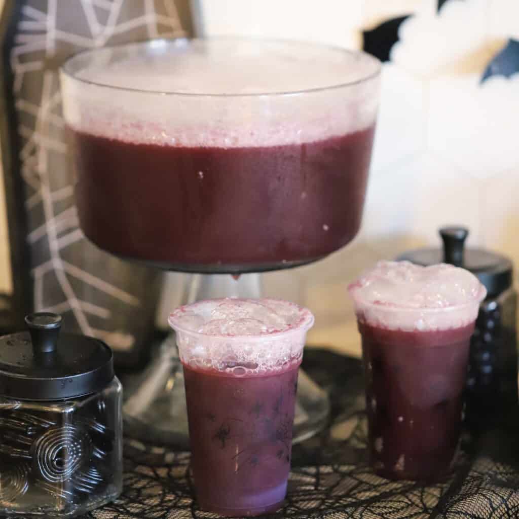 purple witch punch on a table decorated for halloween