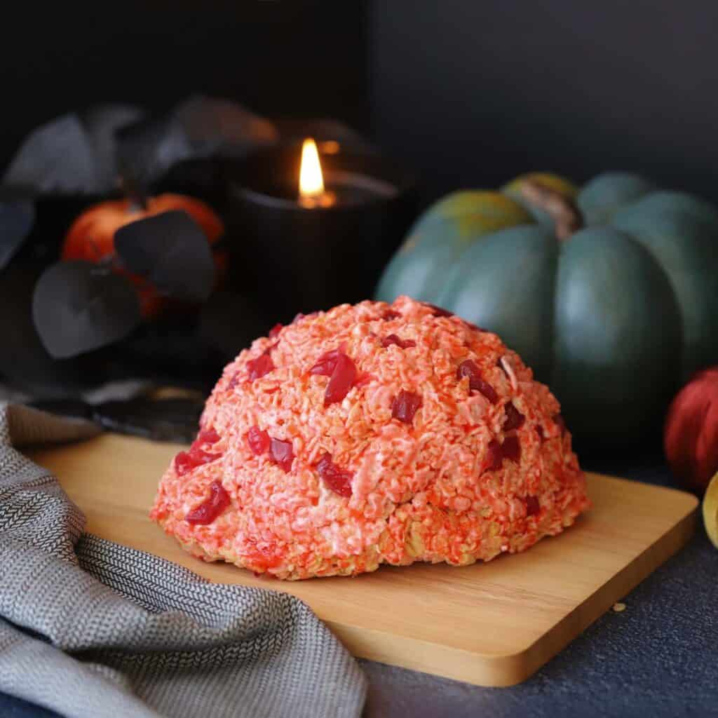 A halloween decorated table with a rice krispies brain. 