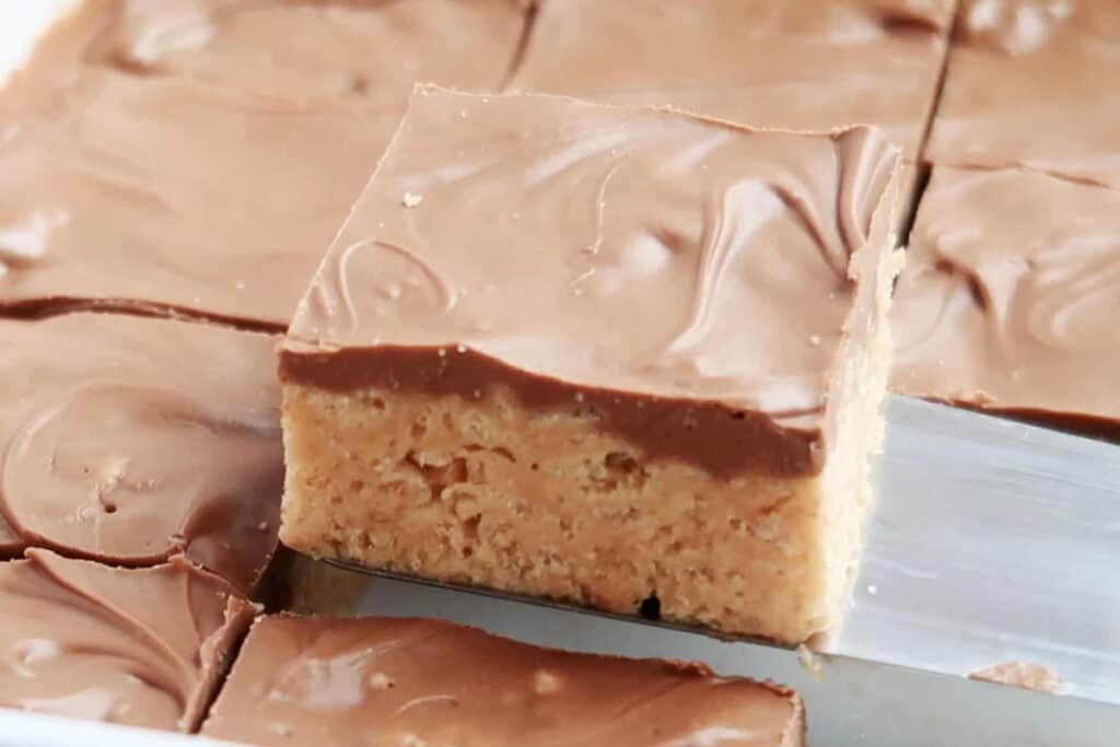 best scotcharoos recipes, easy no bake cookie bars being served on a spatula