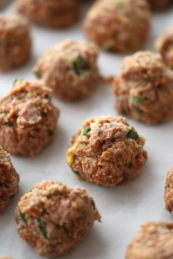 raw italian meatballs on a baking sheet ready to cook, italin spicy meatballs. 