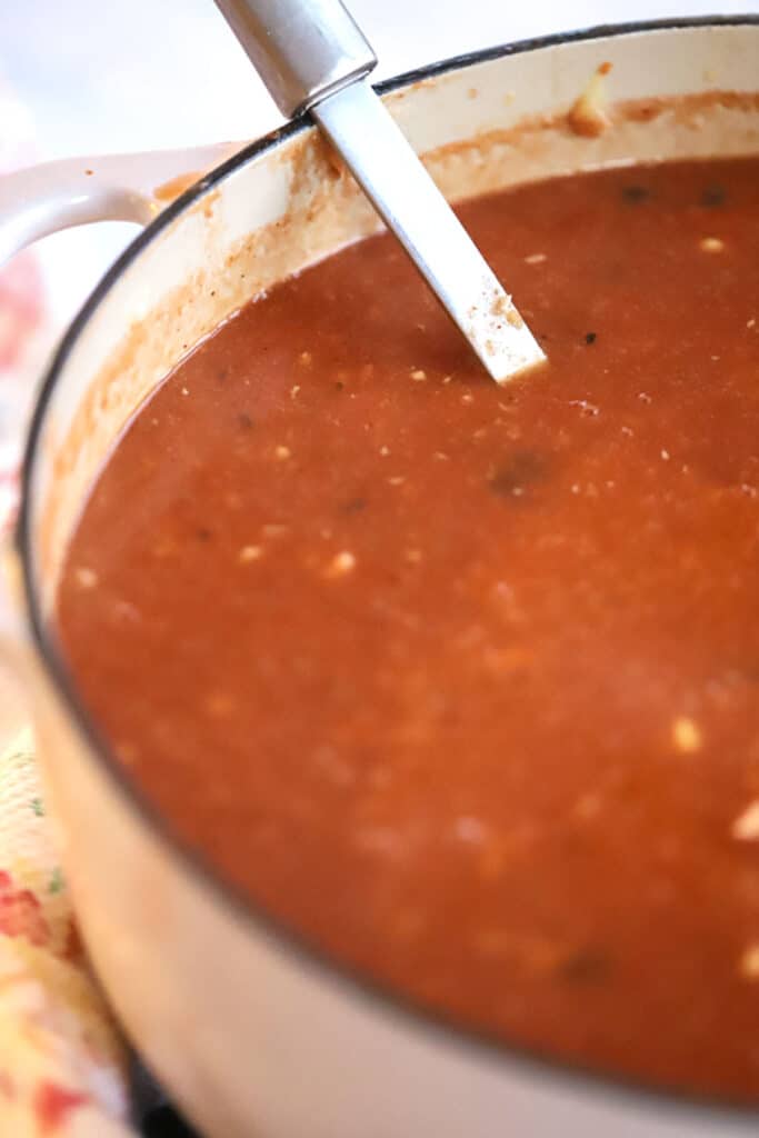 Turkey Enchilada Soup in a large dutch oven with a ladle. turkey enchiladas, leftover turkey soup, southwestern turkey soup, turkey soup ideas, soup with ground turkey.