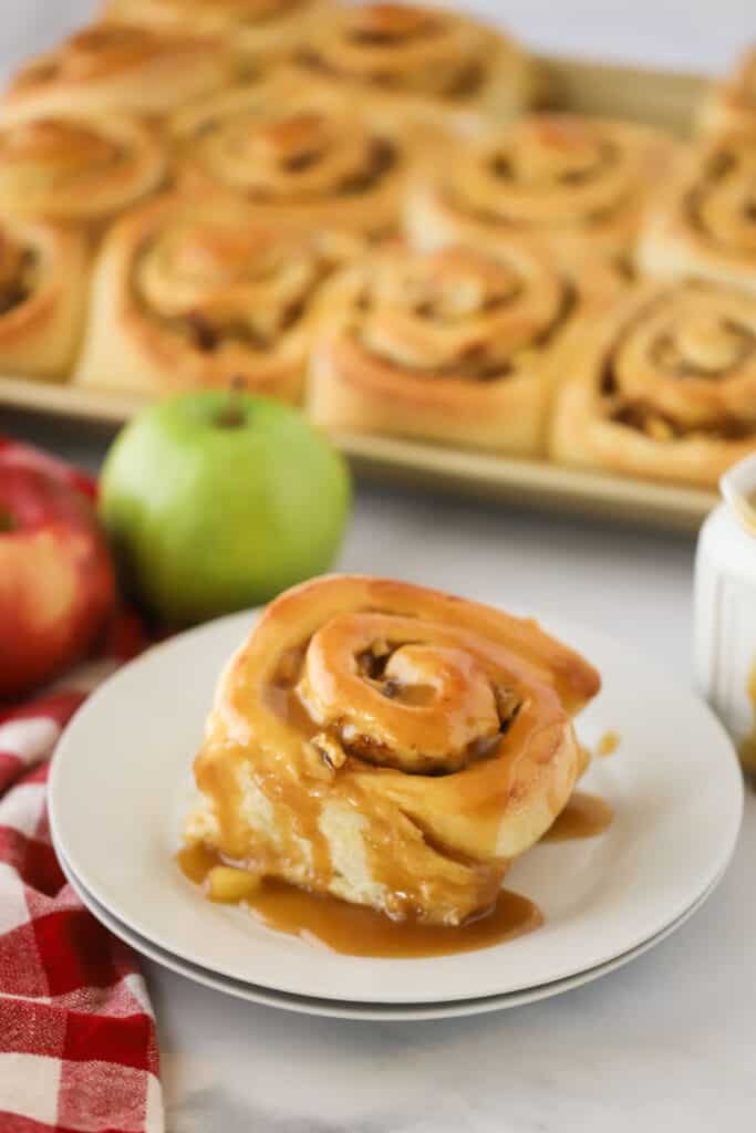 caramel apple cinnamon rolls on a white plate, an easy homemade cinnamon roll recipe that's perfect for fall breakfast.