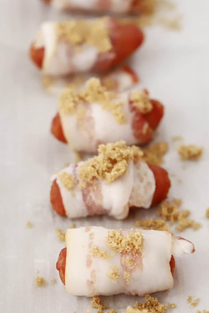 bacon wrapped smokies with brown sugar on top.