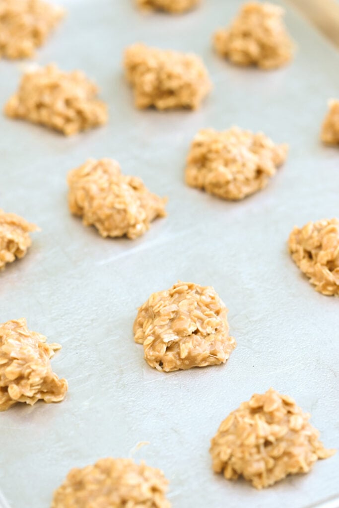 No bake peanut butter and coconut cookies spread out on a baking sheet. One of the best no bake cookies with coconut.