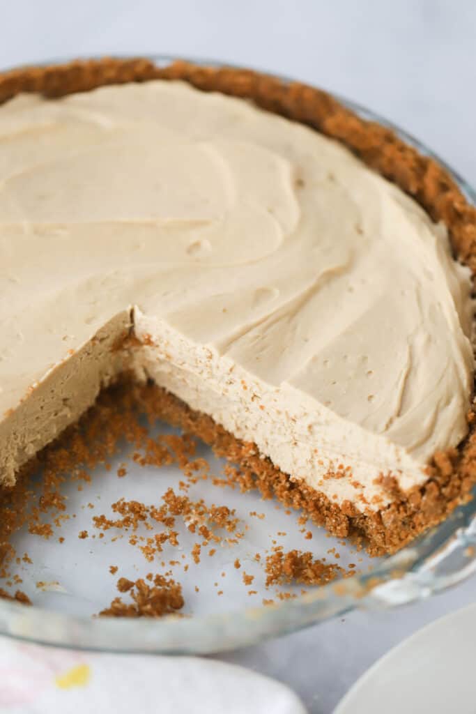 A pie plate with a cookie butter cheesecake made with biscoff cookie crust and a no bake cookie butter cheesecake filling.