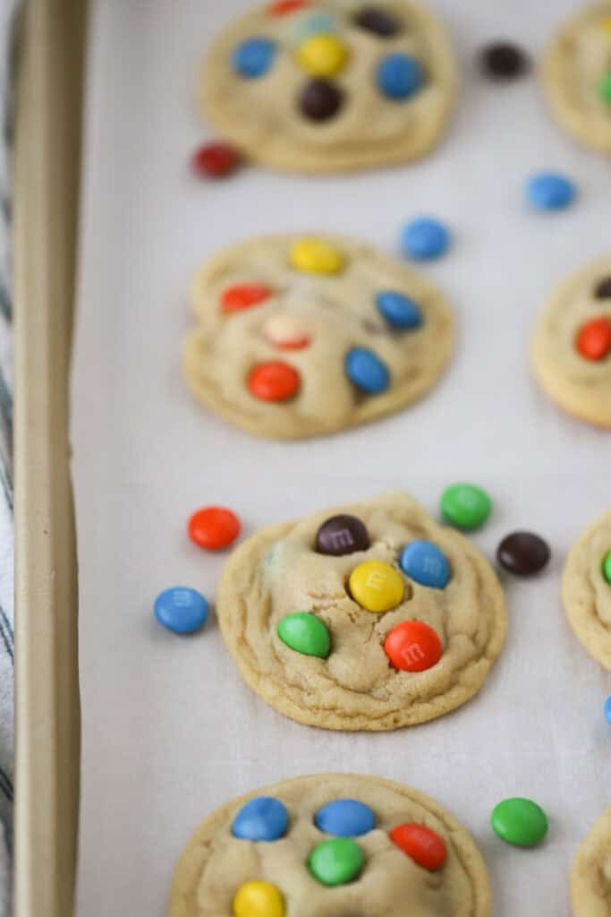 Homemade M&M cookies on a baking sheet.