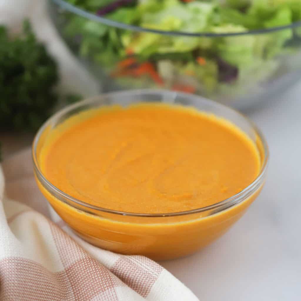 A small bowl full of ginger salad dressing made with carrots, ginger, and other asian-inspired ingredients. It tastes just as good as it does at your favorite Japanese restaurant.