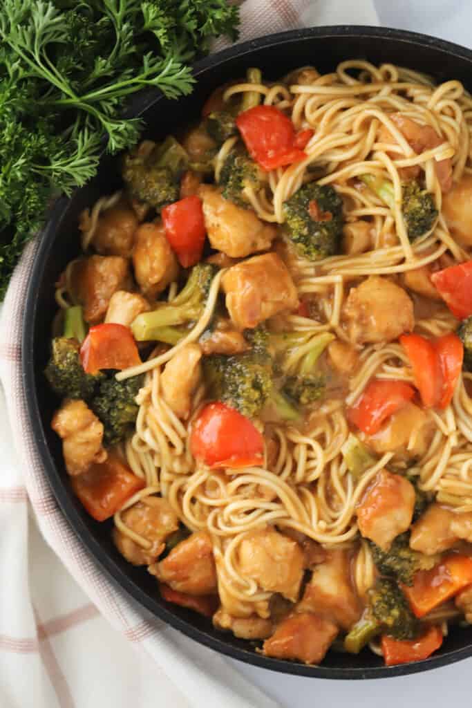 A bowl full of Thai Peanut butter chicken and noodles, an easy lunch or dinner that can be ready in less than 30 minutes.