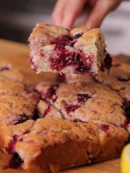 a jammy slice of homemade mixed berry coffee cake with sugar crusted topping.