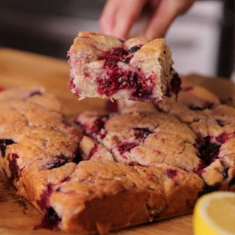 a jammy slice of homemade mixed berry coffee cake with sugar crusted topping.