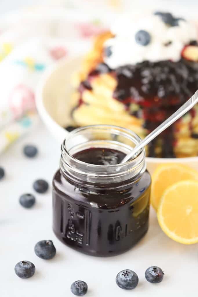 Homemade blueberry syrup recipe in a small glass jar.