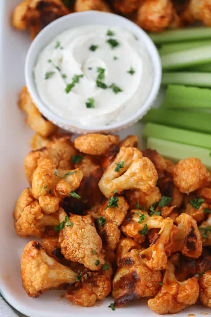 buffalo cauliflower recipe with a side of ranch and celery sticks.