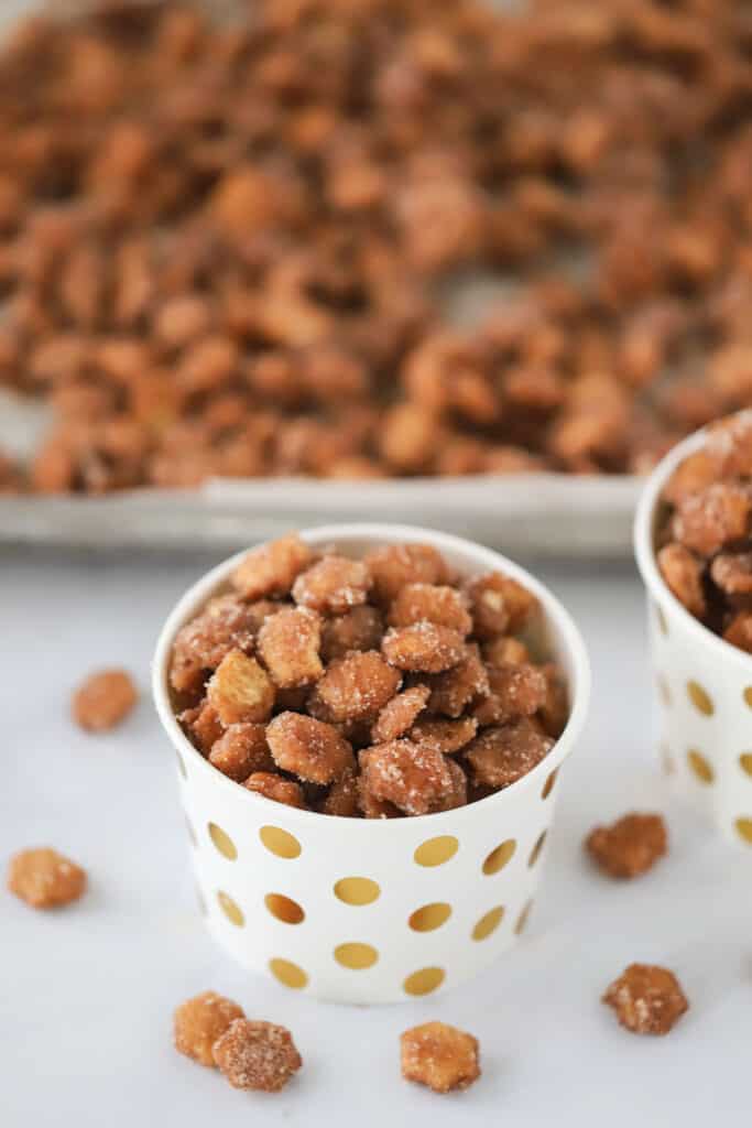 A cup full of churro oyster crackers, an easy and addicting sweet and salty snack mix.