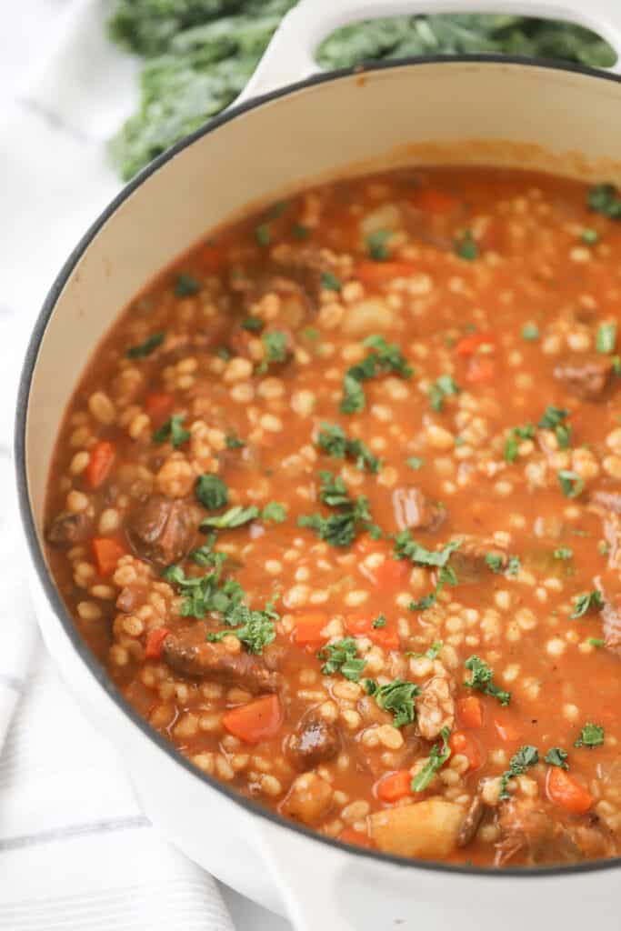 Homemade beef and barley soup recipe in a large dutch oven pot.